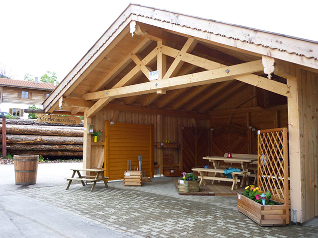 Holzüberdachung mit einer Holzbank darin stehend